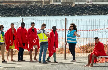 Un agente de la Policía Nacional y otra de Frontex, la agencia europea de fronteras, reciben a los ocupantes de una embarcación en el puerto de Arrecife, el pasado 18 de octubre.