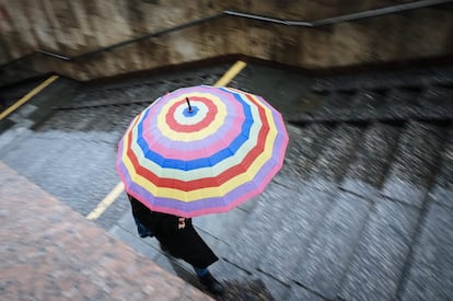 Un alegre paraguas pone una nota de color a un gris y lluvioso día en Kiev (Ucrania).