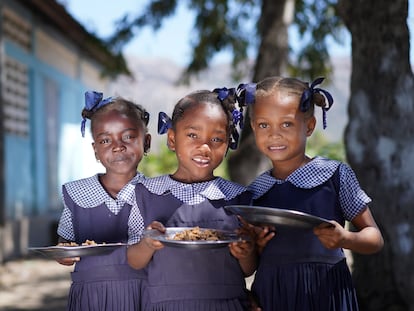 Tres niñas haitianas posan con sus platos de bulgur en su escuela. El Programa Mundial de Alimentos sirve hasta 250.000 menús a diario en las escuelas del país. FOTO: ANTOINE VALLAS/VIDEO: ALEXIS MASCIARELLI (WFP)