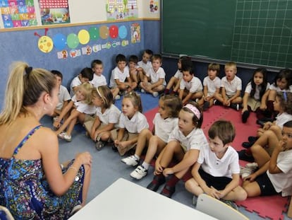 Un grupo de alumnos sigue las explicaciones de una profesora en un colegio en la comunidad de Madrid