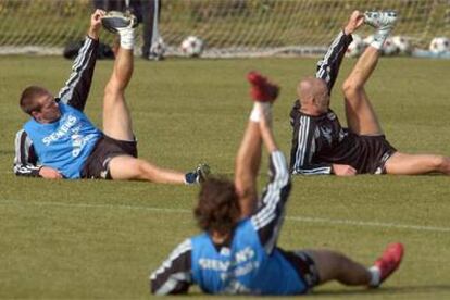 Raúl, de espaldas, y Owen y Beckham, al fondo, durante el entrenamiento madridista de ayer.