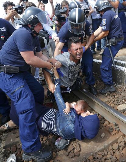 Policías húngaros detienen a un refugiado en las proximidades de la estación de ferrocarril en la ciudad de Bicske (Hungría).