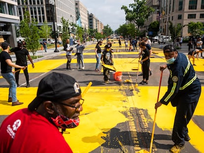 Varios voluntarios pintan el lema Black Lives Matter en el último tramo de la calle 16.