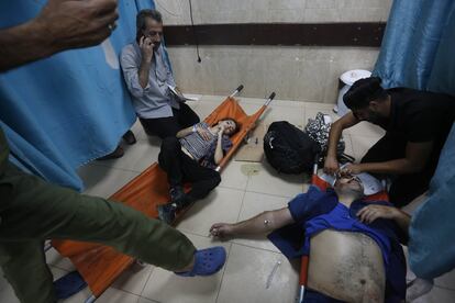 Palestinos heridos a causa de un ataque israelí son asistidos en el hospital de Al Aqsa, en la ciudad de Gaza, este viernes.  
