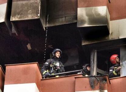 Un equipo de bomberos, en el balcón de uno de los pisos calcinados por el fuego.