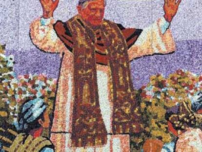 Dos trabajadores dan los últimos toques a un mosaico del Papa junto a la basílica de los Desamparados.