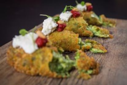 Croquetas al pesto con puré de tomate seco y rúcola.