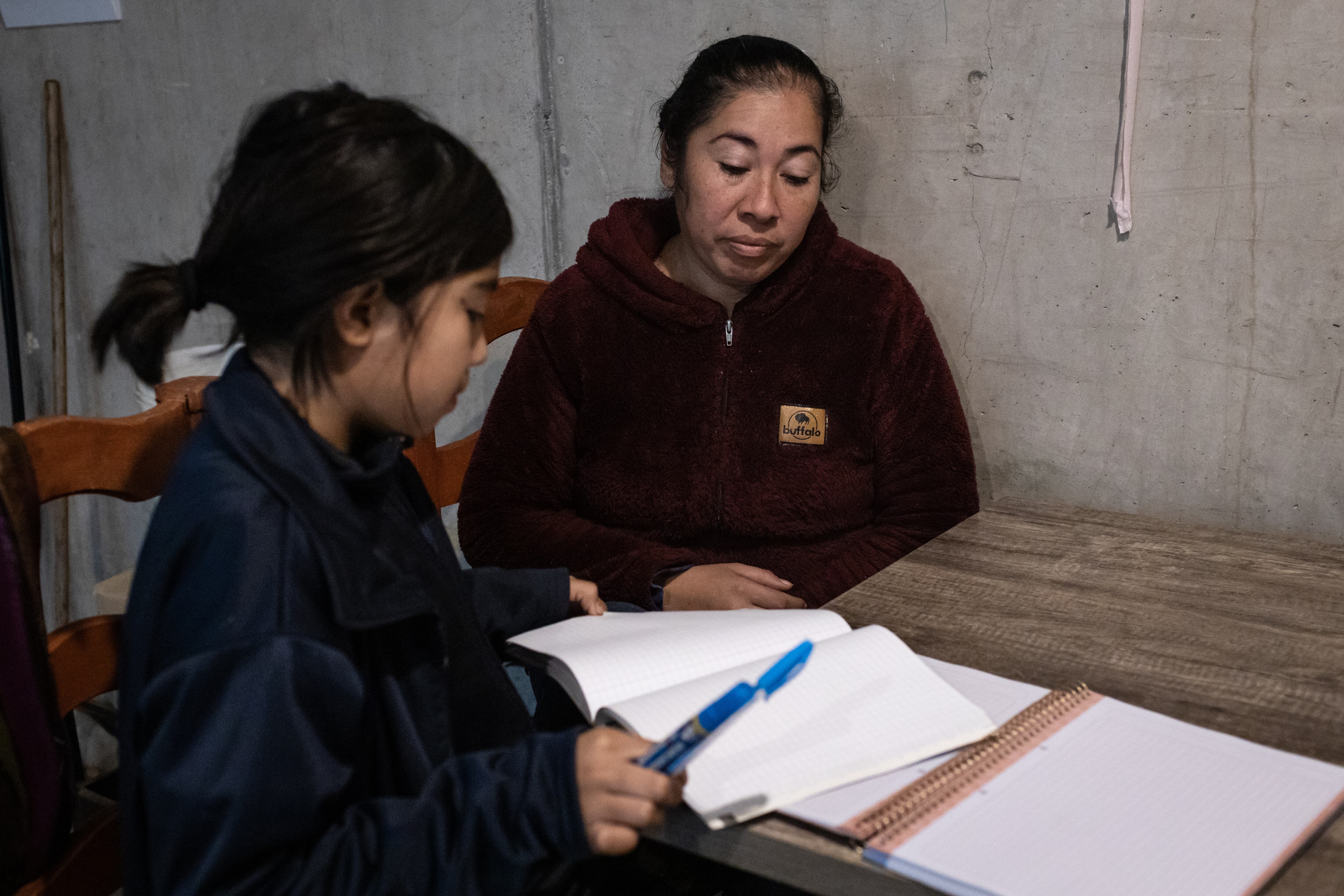 Macarena Antilef ayuda a su hija Sofía, de 9 años, a hacer su tarea del Programa de Integración Escolar, en la comuna de Quilicura (Santiago de Chile), en junio de 2023.