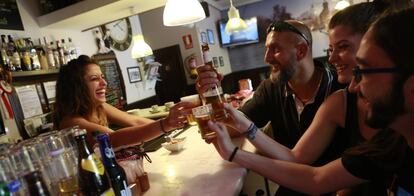 Una camarera y varios clientes de un bar de Madrid.