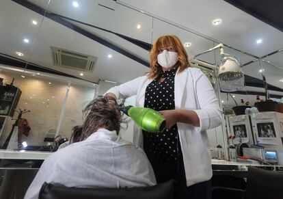 Monique Moreira de Lima atiende a una clienta en su peluquera en Madrid.