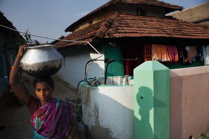 Una mujer lleva un cacharro con agua en la cabeza tras llenarlo en un de los pozo. En Bodhali no hay agua corriente sino una serie de pozos en los que la gente, normalmente las chicas y mujeres, llenan recipientes de agua para el uso doméstico.