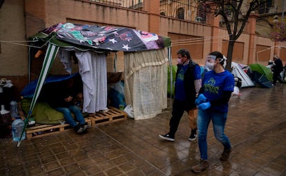 Varios voluntarios reparten comida a personas sin hogar, el pasado jueves en Valencia.