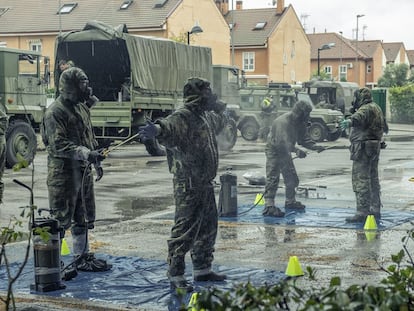 Soldiers disinfect their uniforms after entering a senior residence in Madrid.