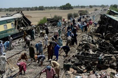 Un grupo de trabajadores repara una vía de tren tras un accidente que dejó 63 fallecidos, en Daharki, Pakistán.