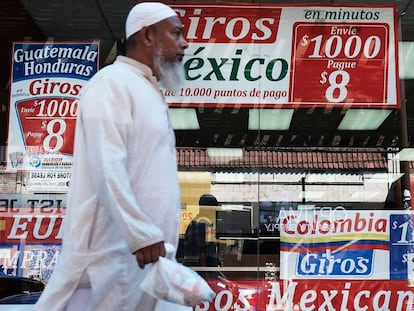 Un hombre camina delante de una tienda especializada en viajes y envío de dinero a Latinoamérica.