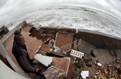 Dos personas observan los destrozos en la terraza de su casa en la playa de Les Marines (Dénia) a causa del temporal marítimo que ha azotado la Comunidad Valenciana.