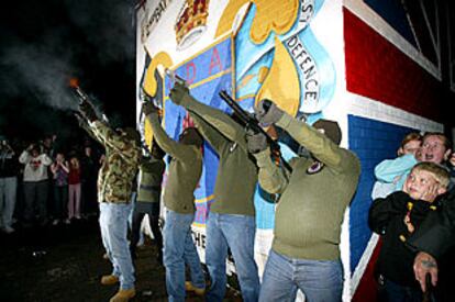 Paramilitares protestantes disparan al aire en un acto unionista celebrado en el área de Belfast.
