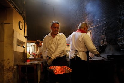 Un hombre quita las brasas de la cocina de la churrería Manuela, en la que se hacen los churros de manera tradicional desde 1872. En la actualidad sólo abre en fechas especiales como los Sanfermines.