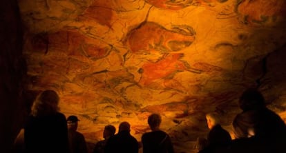 A group of visitors observes the replica of the world-famous cave paintings in Santillana del Mar.