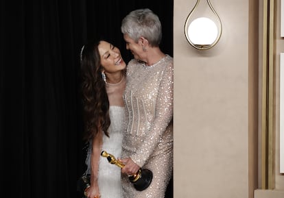 Las actrices Michelle Yeoh y Jamie Lee Curtis, se miran emocionadas en el 'backstage', antes de posar para los medios con sus galardones.