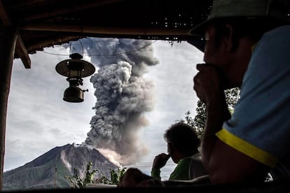 Los aldeanos miran cómo el volcán del Monte Sinabung expulsa ceniza al norte de la isla de Sumatra.