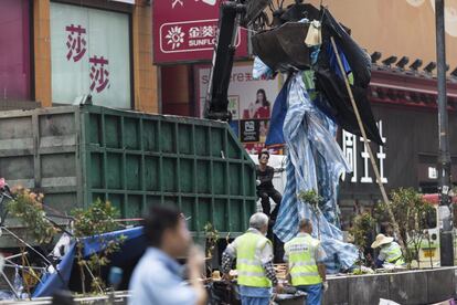 Las protestas, que atrajeron a más de 100.000 personas, han disminuido hasta unos cientos que acampan en coloridas carpas en intersecciones clave en ambos lados de la bahía. En la imagen, trabajadores limpian la calle en Nathan Road en el distrito de Mong Kok en Hong Kong (China).