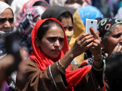 Una mujer musulmana de Cachemira utiliza su tel&eacute;fono mientras asiste a la procesi&oacute;n f&uacute;nebre de un militante local asesinado en la zona de Panjran Lassipora, en la India.
