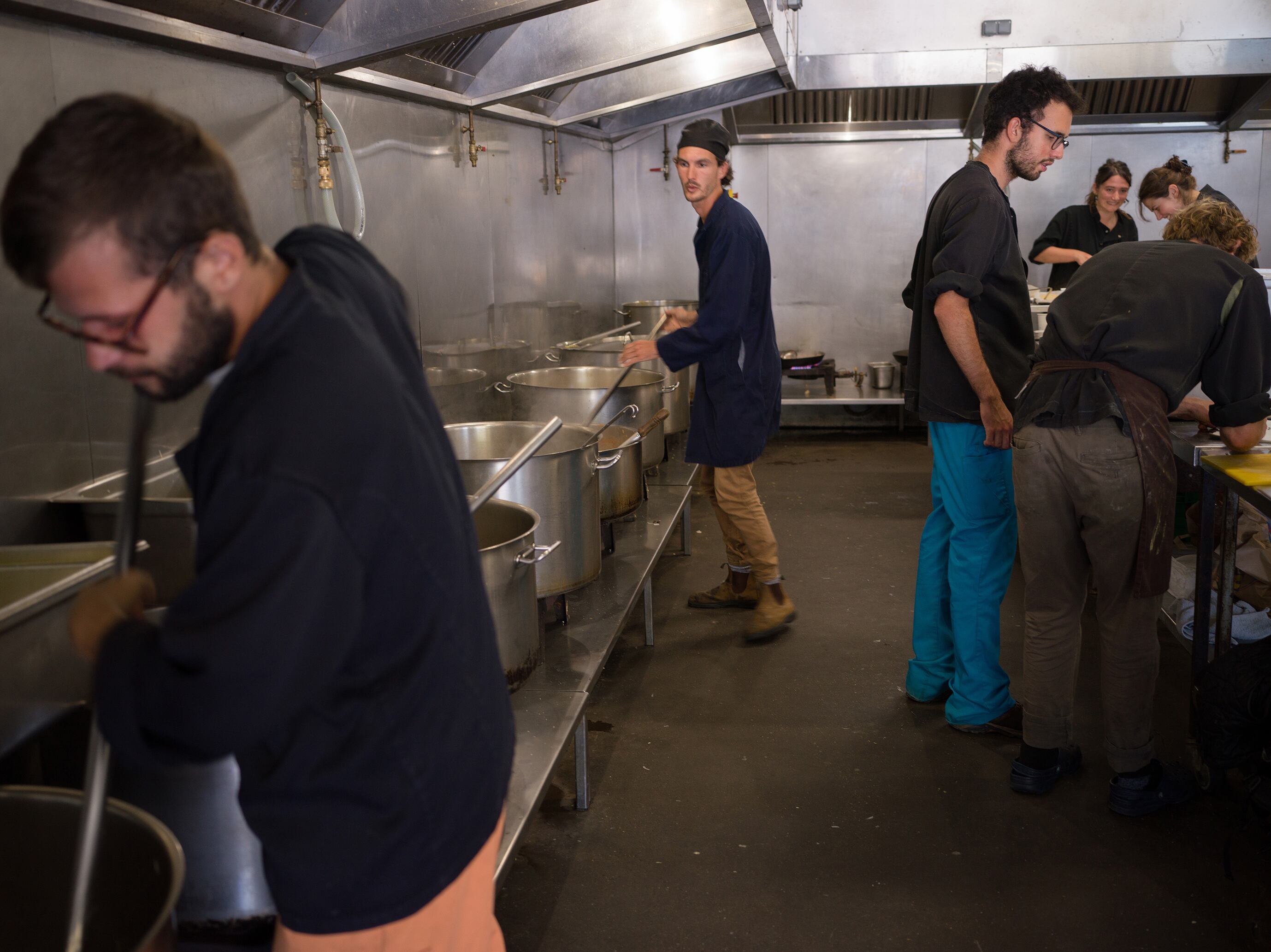 Voluntarios de diferentes ONG trabajan en la cocina preparando comida para el reparto a los inmigrantes.