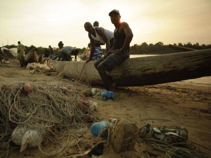 Unos pescadores arreglan las redes tras una jornada de pesca en Sierra Leona.