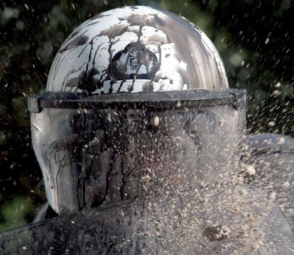 Un policía antidisturbios recibe el impacto de una piedra durante la manifestación en Atenas contra los recortes económicos.