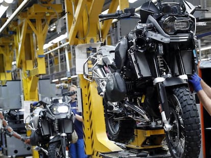 Trabajadores en una cadena de montaje de una fábrica de motocicletas.  