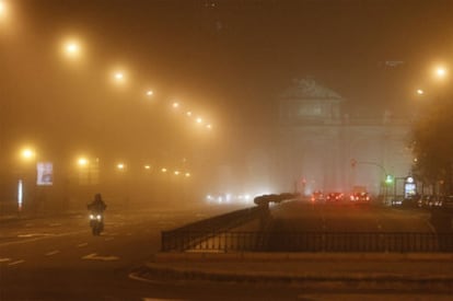 La madrileña Puerta de Alcalá rodeada por la niebla.