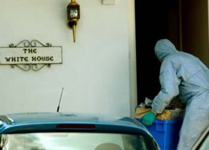 Un experto forense de la policía británica traslada material a la casa de un detenido en la última redada.