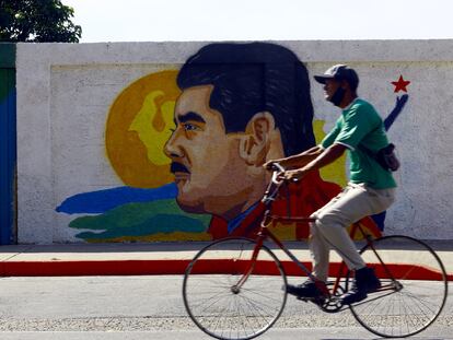 Un hombre pasa junto a un mural del presidente venezolano, Nicolás Maduro.