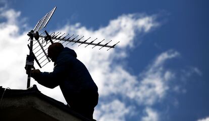 Un antenista resintoniza una antena con amplificador de señal TDT en Madrid.