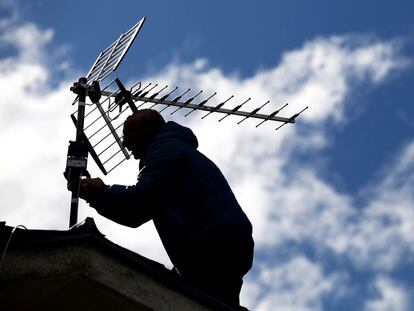 Un antenista resintoniza una antena con amplificador de señal TDT en Madrid.