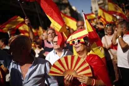 Una dona amb ulleres i ventall amb els colors de la bandera d'Espana protesta durant la manifestació.