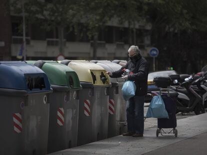 Un vecino de Barcelona tirando la basura en unos contenedores.