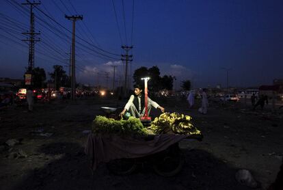 Un vendedor ambulante de frutas espera clientes en una calle de Islamabad (Pakistán).