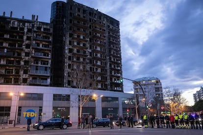 Los reyes de España durante su visita a la zona del edificio incendiado, este lunes.