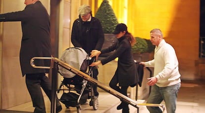 Penélope Cruz y Javier Bardem, a la entrada de su hotel en Londres, con el carrito de su hijo Leo, el 15 de enero de 2012