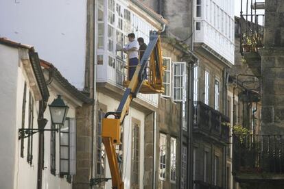 Operarios trabajando en la rehabilitaci&oacute;n de un edificio en el casco hist&oacute;rico de Santiago.