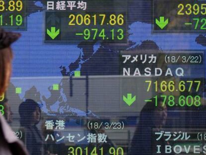 Varios peatones pasan delante de un panel con cotizaciones burs&aacute;tiles en Tokio (Jap&oacute;n). 