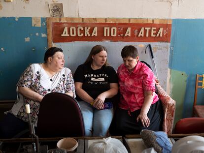 Tres mujeres sentadas en Kiev, Ucrania en una planta de fabricación donde trabajaban personas con discapacidad visual, mayo de 2023