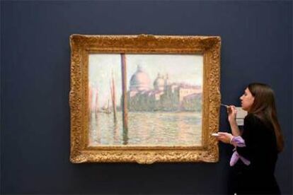 Una empleada retoca el marco de <i>El Gran Canal,</i> de Monet, la estrella de la subasta de Sotheby&#39;s.