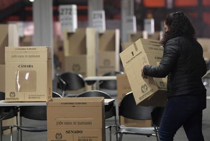 A woman works at a polling station ahead the parliamentary elections in Bogota, on March 11, 2022. - Colombians will vote on March 13 to draw up a shortlist of presidential candidates as well as electing members of the Parliament. (Photo by Raul ARBOLEDA / AFP)