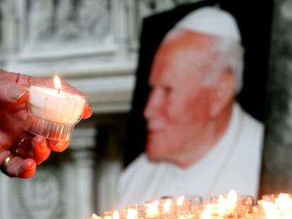 Una persona enciende una vela ante una imagen del papa Juan Pablo II en la catedral de Saint G&ouml;dele de Bruselas.