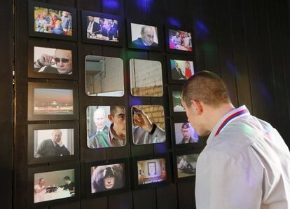 Un hombre se mira en un espejo del bar President Cafe, en Siberia (Rusia), decorado con distintas fotografías del presidente ruso Putin.