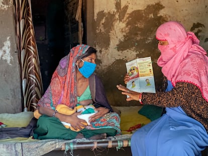 Reena Patidar, activista de una asociación en favor de la lactancia materna, explica los beneficios de la misma a Latha Raju Masaur en Jethana, un pueblo de India.