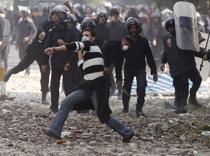 Un policía de paisano lanza piedras contra los manifestantes en la plaza de Tahrir